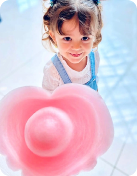 Happy customer holding a freshly-spun cotton candy cone from Funland Vending in Dubai
