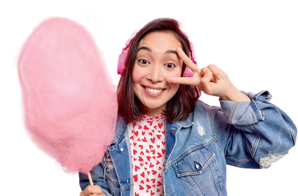 Happy young customer enjoying fresh pink cotton candy from a Funland Vending machine in Dubai